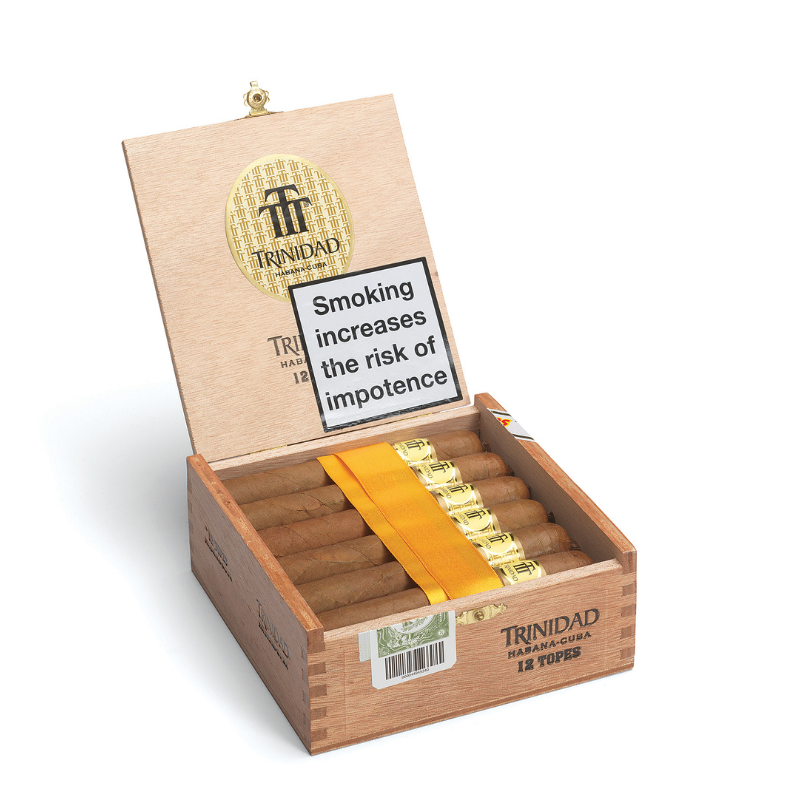 Open wooden box of Trinidad cigars with a warning label on a white background